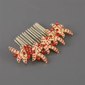Detailed close-up of a golden flower hair comb with red rhinestones and ten metal teeth - Red Rhinestone Style