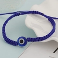 Detail of hand-woven deep blue rope bracelet with a central blue glass evil eye charm - Deep Blue Single Eye (BN-0149-3)