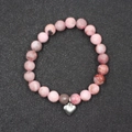 Primer plano de pulsera de cuentas de mármol rosa con dije de corazón plateado en fondo gris - Estilo Corazón de Acero Inoxidable Zebra Rosa (BNS-0334) / Rosa