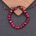 Macro detail van rozerode tijgeroog steen kralen op een verstelbare zwarte armband - 16.5+5+5cm / Magenta Gestreepte Jaspis