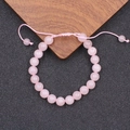 Detailansicht eines Rosenquarz-Perlenarmbands mit verstellbarem rosa Webband - Rosenquarz