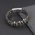 Detalle macro de pulsera de cuero trenzado para hombre con anillos vintage y cierre magnético - Negro Blanco Vintage y Plateado