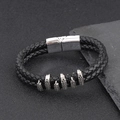 Detalle de pulsera de cuero trenzado doble con adornos de garras metálicas y cierre magnético - Negro + Plata