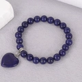 Macro detail of natural lapis lazuli beaded bracelet with a heart pendant on stone background - Lapis Lazuli (BNS-0390)