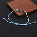Detail eines verstellbaren hellblauen Webarmbands mit drei ineinandergreifenden Herzen - Blue And Silver Triple Heart Bracelet