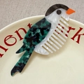 Macro shot of bird-shaped acetate hair comb with marble patterns on a ceramic plate - Bird