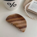 Caramel striped acetate hair claw clip for elegant bun hairstyles in minimalist setting - Semi-circle