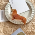 Detailed view of dachshund hair claw clip in amber marble texture on ceramic plate - Rural Dog