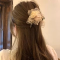 Dettaglio molletta per capelli con fiore in organza color champagne su capelli castani - Albicocca