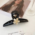 Détail de la pince à cheveux fleur noire élégante avec pétale crème et centre doré brillant - Noir