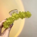 Gros plan sur la pince à cheveux muguet vert translucide avec son ressort doré - Grand / Vert