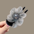 Macro detail of organza camellia hair claw clip with shimmering dark rhinestones - Gray