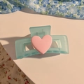 Detail einer matten hellblauen Schmetterlings Haarklammer mit rosa Herzverzierung - Blaues Herz Dekor Design