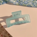 Nahaufnahme einer matt hellblauen quadratischen Haarklammer mit Blumendetail - Blaues Quadrat Hohl-Design
