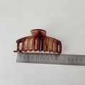 Detail view of a 11cm matte tortoiseshell hair claw clip measured with a metal ruler - Bone Style Amber