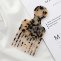 Close-up of tortoise shell pattern acetate hair comb on premium white silk background - Beige