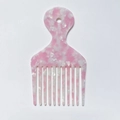 Macro view of pink marble acetate hair pick showing fine teeth texture and hanging hole - Pink White