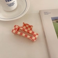 Detail view of large red and white checkered claw clip beside a coffee cup on magazine - Pink 10.5cm