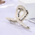 Detail of acetate shark hair claw with pearlescent marble texture and silver metal spring - White