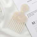 Detailed macro view of pearlescent acetate hair comb on silk fabric with marble pattern - Mermaid Color