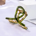 Close-up of deep green acetate hair claw clip with golden metal teeth on white silk - Glass Green