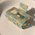 Close-up detail of blue and beige checkerboard hair claw clip in a white ceramic bowl - Yellow Blue