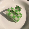 Detail view of green and white checkered hair claw clip on a white ceramic plate - Pale Green