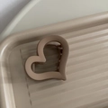 Dettaglio della pinza per capelli beige opaca a forma di cuore su vassoio d'esposizione - Marrone