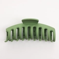 Close-up of a large matte grass green shark hair claw clip with a sleek ergonomic handle - 11cm / Matte Green