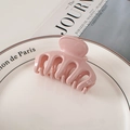 Glänzende hellrosa Haarklammer für Damen auf einem minimalistischen Magazin-Hintergrund - Rosa