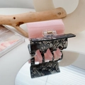 Détail de la pince à cheveux en résine rose et marbre gris avec ressort en métal doré - Noir + Rose