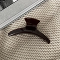 Detailansicht der dunkelbraunen Haarklammer mit Barrette-Schriftzug auf Strickhintergrund - Groß / Kaffeebraun