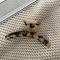 Makroaufnahme einer großen Haarklammer mit Leopardenmuster auf beigem Strickstoff - Groß / Beigefarbenes Schildpatt