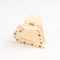 Detail of heart-shaped cream acetate hair claw clip with amber rhinestones and gold spring - 6cm / White (A3-3-21)