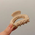 Nahaufnahme der beigen Acetat-Haarklammer mit moliveny-Logo und halbrunder hohler Form - Beige