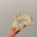 Detail der lichtdurchlässigen, perlmutt-beigen Acetat-Haarklammer mit moliveny-Logo - Grau Irisierend
