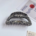 Close-up of hollow acetate hair claw clip with black and white spotted pattern - Spotted Black
