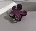Close-up of deep purple camellia hair claw clip with glossy finish and logo detail - Deep purple