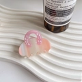 Dettaglio della pinza per capelli in acetato con trama marmo rosa e motivo numerico - Bianco Gemma