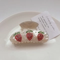 Détail de la pince à cheveux en acétate avec motifs de fraises en strass sur base crème marbrée - M / Blanc de jade