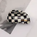 Dettaglio di un fermaglio per capelli a scacchi bianco e nero con scritte in oro - Griglia Bianco e Nero - Semicerchio