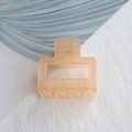 Detail view of a translucent amber orange square hair claw clip with a sturdy metal spring - 5cm / Jelly Orange