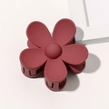 Close-up of a matte dark red flower claw clip with five petals on a minimalist background - Burgundy