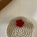 Détail d'une mini pince à cheveux fleur rouge foncé sur un fond texturé au crochet - Petite Fleur Rouge
