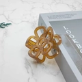 Detailed view of hollow flower claw clip in translucent amber resin on marble surface - 7cm / Caramel color