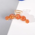 Détail d'une grande pince à cheveux avec perles marbrées ambrées et effet nacré - Orange Champagne