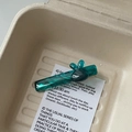 Détail de la pince à cheveux en acétate vert marbré dans une boîte cadeau minimaliste - Bleu lac