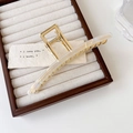 Macro view of a 13cm large gold metal claw clip with elegant ivory acetate accents - Iridescent White 13cm
