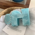Close-up of H-shaped hair claw clip in blue marble acetate with sparkling rhinestones - 9cm / Blue