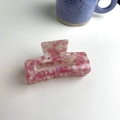Detailed top view of a large pink marble acetate hair claw clip on white table - About 9cm / Pink